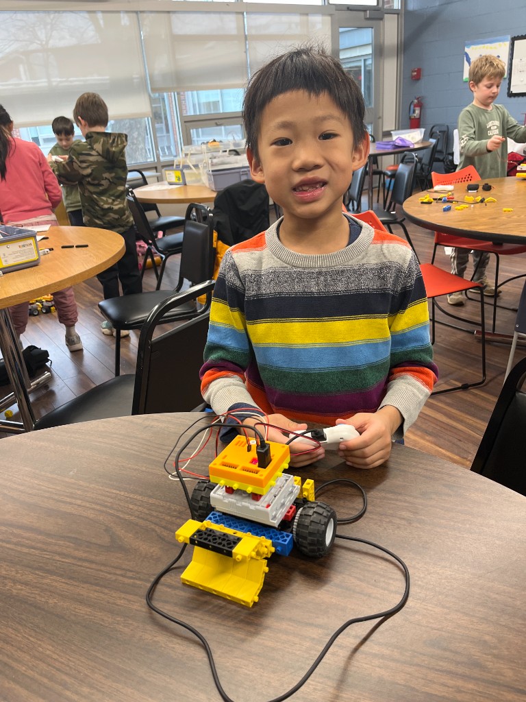 Student with a bulldozer robot and remote